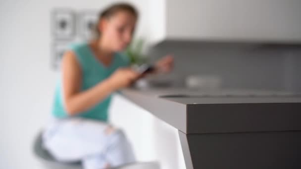 Woman uses a smartphone while eating her breakfast — Stock Video