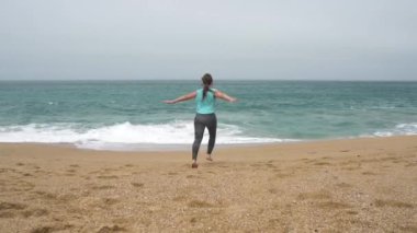 Plaj boyunca çalıştıran atletik kadın. Ağır çekim