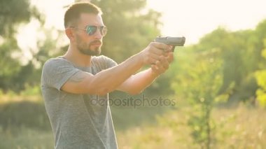 Genç adam bir silahtan ateş ediyor, yakın çekim