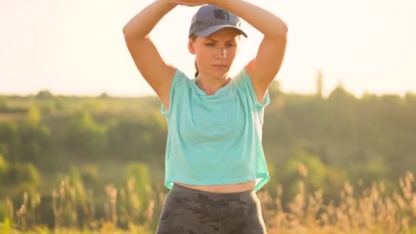 Mujer fitness se calienta y se estira al aire libre antes de correr. Movimiento lento — Vídeos de Stock