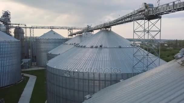 Vlucht onder graanschuren en liften of olie opslag op zonsondergang — Stockvideo