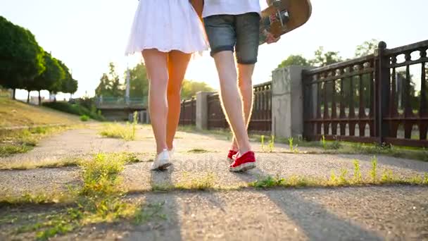 Pareja joven enamorada caminando por la calle al atardecer. Movimiento lento — Vídeo de stock