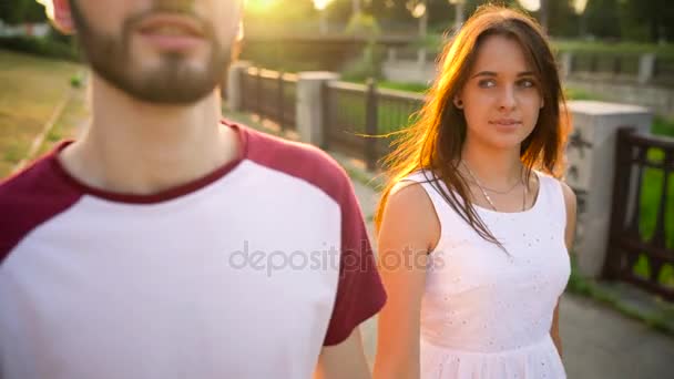 Pareja joven enamorada caminando por la calle al atardecer — Vídeo de stock