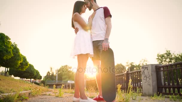 Młoda para w miłość, pocałunki na ulicy o zachodzie słońca — Wideo stockowe
