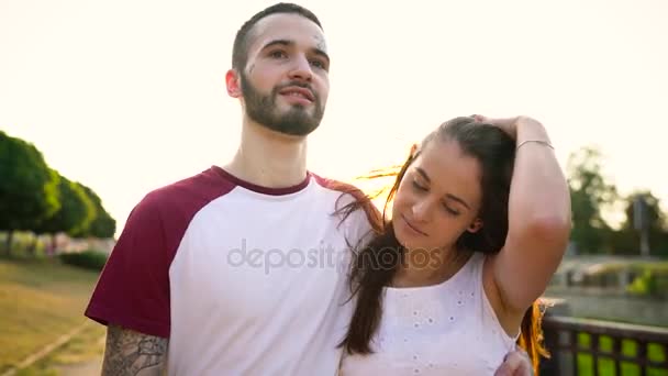 Pareja joven enamorada caminando por la calle al atardecer — Vídeos de Stock