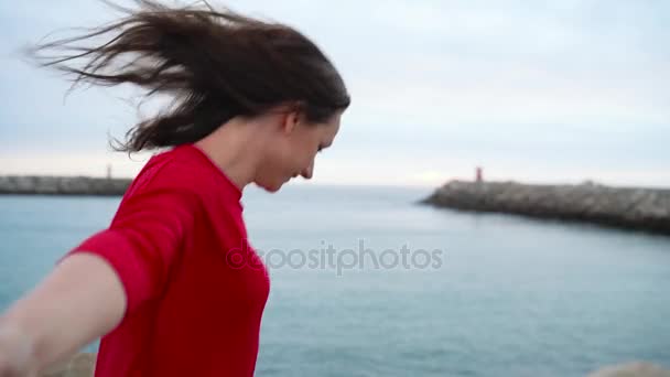 Слідуйте за мною - щаслива молода жінка в червоній сукні тягне хлопців за руку, йдучи до маяка на пляжі на заході сонця. . . Повільний рух — стокове відео