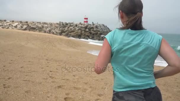 Mulher atlética correndo pela praia. Movimento lento — Vídeo de Stock