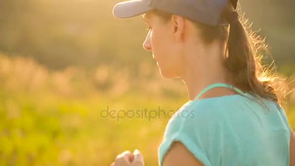 Woman runs outdoors at sunset, slow motion — Stock Video
