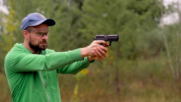 El joven está disparando con un arma, de cerca. Movimiento lento — Vídeos de Stock