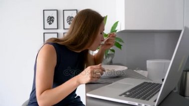 Çekici kadın bir kahvaltı yaparken onu laptop kullanma