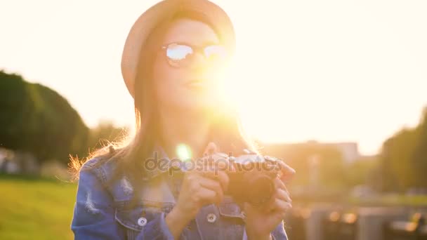 Girl is walking around the city and taking photos of nature and sights on a film camera — Stock Video