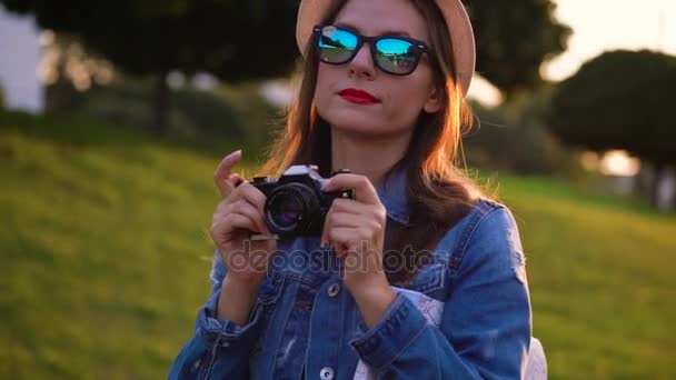 Flicka promenader runt staden och ta bilder av natur och sevärdheter på en filmkamera — Stockvideo