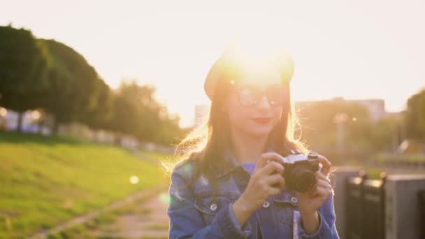 Fille se promène dans la ville et de prendre des photos de la nature et des sites sur une caméra de cinéma — Video