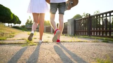 Gün batımında cadde boyunca yürüyüş aşık genç Çift