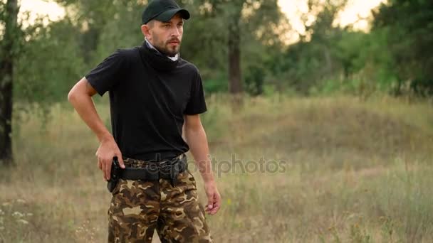 Jeune homme en camouflage tirant à partir d'une arme, gros plan — Video