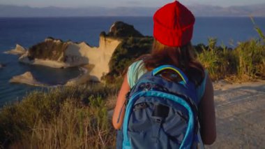 Kadın bir sırt çantası ile fotoğraf Cape Drastis Corfu Island, Yunanistan'ın yapar.