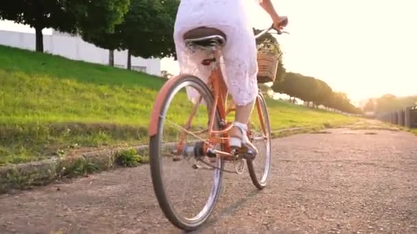 Mulher bonita nova que monta uma bicicleta no por do sol. Movimento lento — Vídeo de Stock