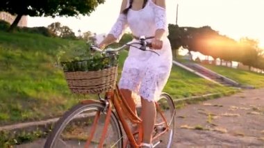 Günbatımında bir bisiklet sürme genç güzel kadın