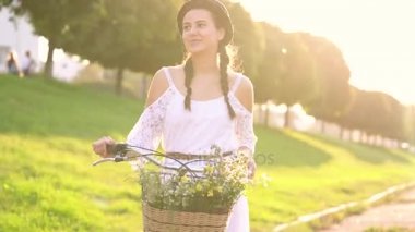 Günbatımında bir bisiklet sürme genç güzel kadın