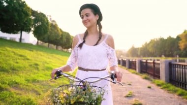 Günbatımında bir bisiklet sürme genç güzel kadın