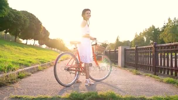 Junge schöne Frau auf dem Fahrrad bei Sonnenuntergang — Stockvideo