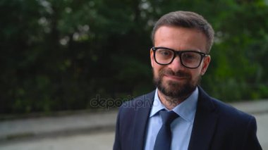 Resmi elbiseli bir genç gülümseyen beyaz adam portresi. Ağır çekim