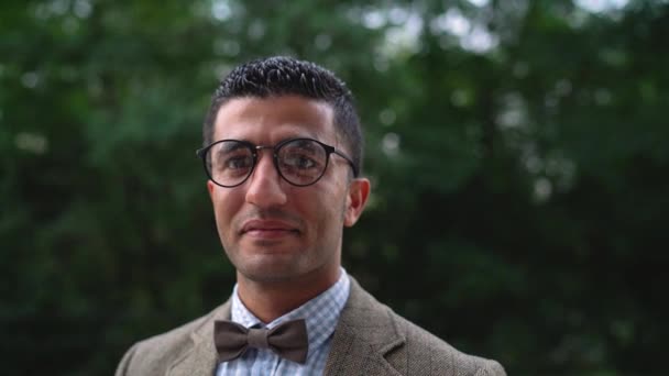 Retrato de un joven árabe sonriente con gafas. Movimiento lento — Vídeo de stock