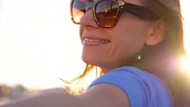 Beni takip - mutlu genç kadın güneş gözlüğü çekerek el çocuklar. Elinde bir sürü yat ve tekne marina yürüme el, yakın çekim. Ağır çekim
