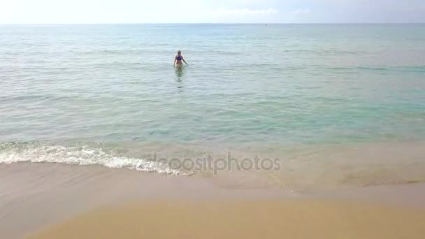 Aerial view of a woman comes out of the clear sea — Stock Video