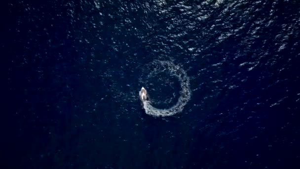 Luftaufnahme eines Motorbootes, das einen Kreis im Meer entwirft und schnell navigiert — Stockvideo