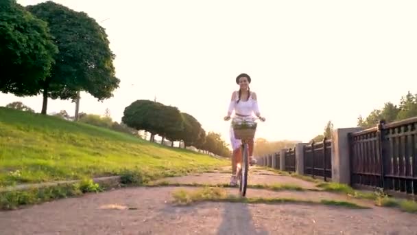 Giovane bella donna in bicicletta al tramonto — Video Stock