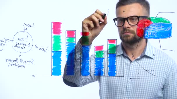 El hombre dibuja varias tablas de crecimiento, calculando las perspectivas de éxito en una moderna oficina de vidrio — Vídeo de stock