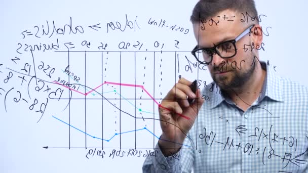 Homem desenha vários gráficos de crescimento, calculando perspectivas de sucesso em um escritório de vidro moderno — Vídeo de Stock