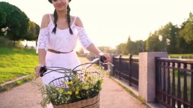 Günbatımında bir bisiklet sürme genç güzel kadın