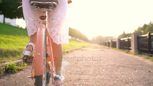 Junge schöne Frau auf dem Fahrrad bei Sonnenuntergang — Stockvideo