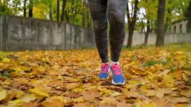 Bir sonbahar parktan günbatımında çalışan kadın bacak yakın çekim.