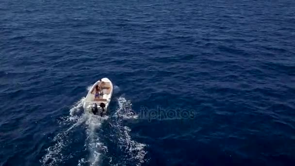 Estudio aéreo de una pareja en un barco viajan juntos en un cálido día de verano. Mujer conduciendo un barco a motor — Vídeo de stock