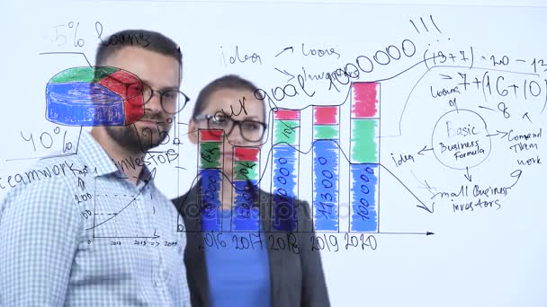 Man en vrouw bespreken de bedrijfsstrategie voor succes in een moderne glas-kantoor — Stockvideo