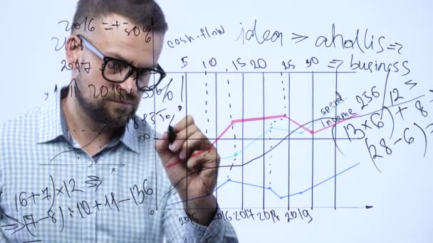 Homem desenha vários gráficos de crescimento, calculando perspectivas de sucesso em um escritório de vidro moderno — Vídeo de Stock