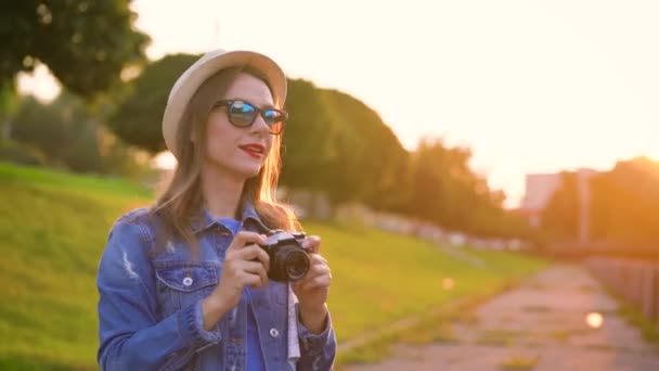 La fille se promène dans la ville et prend des photos de la nature et des sites touristiques sur un appareil photo. Mouvement lent 