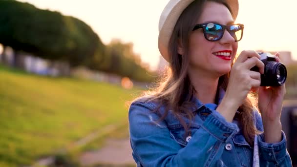 Menina está andando pela cidade e tirar fotos da natureza e pontos turísticos em uma câmera de filme — Vídeo de Stock