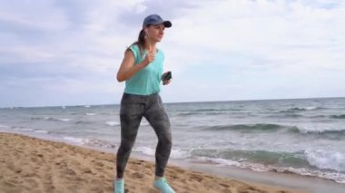 Plaj boyunca çalıştıran atletik kadın