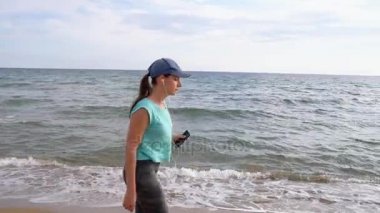 Sahilde yürüyüş kulaklık ile atletik kadın