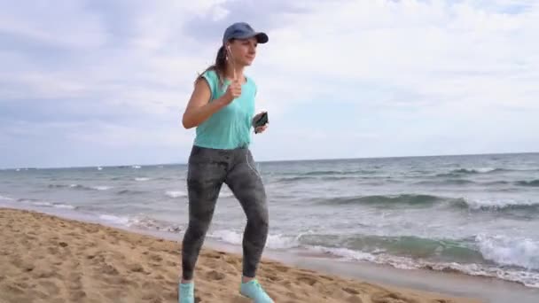 Sportieve vrouw loopt langs het strand — Stockvideo