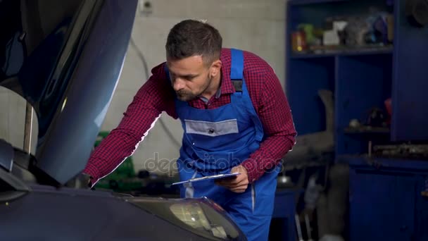 Service automobile, réparation, entretien et concept des personnes - le mécanicien vérifie la qualité du travail effectué — Video