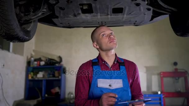 Auto service, reparatie, onderhoud en mensen concept - monteur controleert de kwaliteit van het uitgevoerde werk — Stockvideo