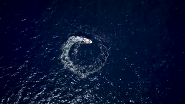 Flygfoto över en motorbåt som utforma en cirkel i havet Navigera snabbt — Stockvideo