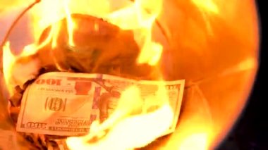 Çöp yakma dolar yakın çekim yapabilir ve bir adam yeni faturaları ateşe atar. Ağır çekim