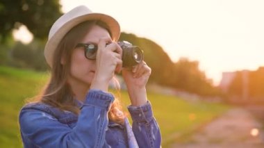 Kız şehir ve doğa ve sights alarak fotoğraf çevresinde bir film kamerası üzerinde yürüyor. Ağır çekim