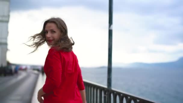 Mulher de vestido vermelho corre ao longo da orla na costa do mar — Vídeo de Stock